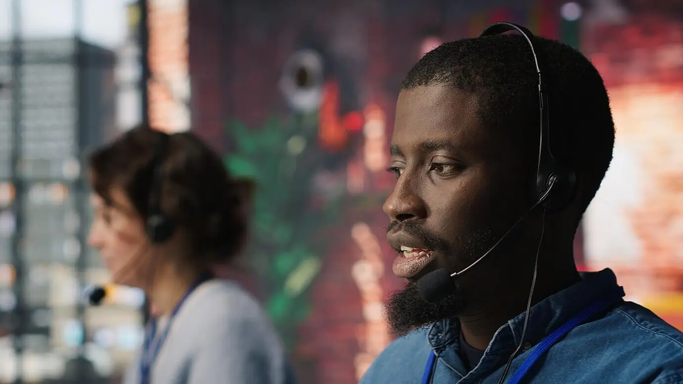 Personal diverso de un centro de atención al cliente asistiendo a clientes con la instalación de software.