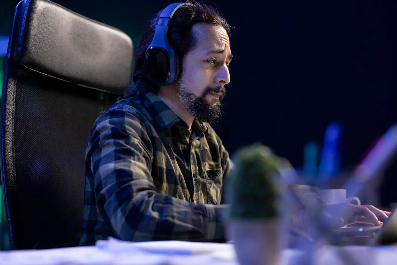 Hombre triste con auriculares asiste a una videollamada.